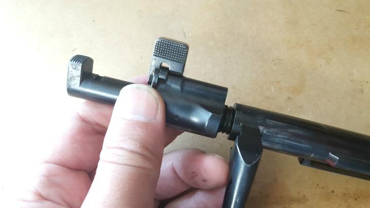 The bolt shroud should easily unscrew from the bolt body now. Note the cocking piece is held under spring tension by the safety lever.
